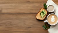 Fresh avocado toast and two cups of coffee with latte art on wooden table background with copy space, top view morning breakfast composition.