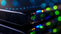 Network server rack with colorful LED indicators glowing in dark data center. Close up view of modern computing equipment showing active status lights.