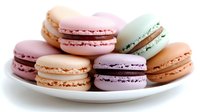 Colorful French macarons in pastel pink, mint, lavender, and peach arranged on white plate, sweet meringue sandwich cookies with cream filling.