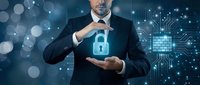 Professional businessman in dark suit protecting digital security lock symbol with hands against futuristic technology background with circuit patterns.
