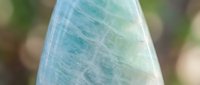 Polished fluorite crystal specimen displaying natural blue and green color bands with translucent mineral formations for geology education and collection.