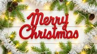 Merry Christmas red sign on white wooden background framed with fir branches, pine cones, silver tinsel, and glowing fairy lights.