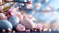 Decorated Easter eggs in pastel blue and pink with glitter dots nestled among delicate cherry blossoms against soft bokeh lights creating festive spring atmosphere.