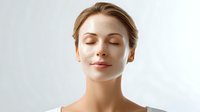 Young Caucasian woman with closed eyes and serene expression against white background, showcasing natural beauty and wellness for spa, skincare, and meditation concepts.