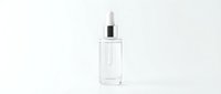 Clear glass dropper bottle with white pipette cap isolated on white background for skincare serum cosmetic product packaging design.