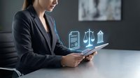 Young businesswoman in black suit using tablet with glowing legal icons, scales of justice, contract and courthouse symbols floating above.