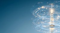 Glowing communication tower with spiral light trails and sparkles against deep blue sky, modern technology concept for wireless connectivity and digital networks.