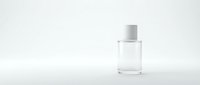 Clear glass perfume bottle with white cap on minimalist white background for cosmetic branding and product photography.