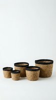 Set of five woven jute baskets with black trim in various sizes arranged on white background for home organization and storage solutions.