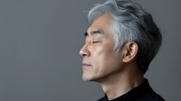 Senior Asian man with gray hair and black turtleneck sweater in profile view against gray background, eyes closed in peaceful meditation or mindful moment.