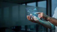 Professional businessman using futuristic holographic tablet with digital interface in modern office environment for business technology applications.