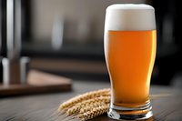 Fresh cold craft beer glass with foam head and wheat ears on wooden table, dark background with copy space for menu and advertising.