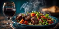 Grilled beef steaks with quinoa salad, cherry tomatoes and herbs on rustic plate with red wine glass. Steam rising from hot gourmet dinner meal.