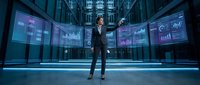 Professional businessman analyzing financial data on multiple digital screens in modern corporate environment for business intelligence presentations.