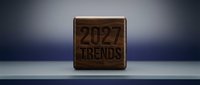 Wooden cube with engraved text 2027 Trends on a shelf, dark walnut texture, studio lighting, business forecast and future planning concept.