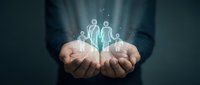 Professional businessman holding glowing family protection symbol in cupped hands representing insurance coverage and financial security services.