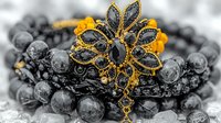 Elegant vintage brooch with black gemstones and golden details on dark beaded jewelry background, selective color macro photography highlighting ornate floral design pattern.