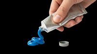 Hand squeezing blue toothpaste from tube onto white background. Isolated png asset ready for dental care, hygiene, and health design projects, t-shirts, clipart, and print-on-demand products.