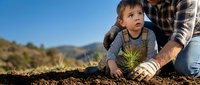 Young boy and adult man planting seedling together in soil outdoors, teaching environmental conservation and sustainable gardening practices.