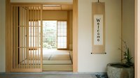 Traditional Japanese room interior with sliding shoji doors, tatami floor, hanging scroll, and minimalist zen decor in neutral tones.
