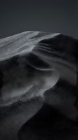 Dramatic black sand dunes with flowing curves and shadows creating abstract desert landscape patterns against dark moody sky for artistic projects.