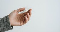 Hand holding white pills or medication tablets against clean background for healthcare and pharmaceutical concepts.