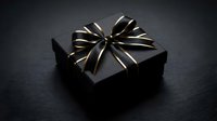 Elegant black gift box with gold ribbon bow on dark surface for luxury packaging, special occasions, holidays, birthdays, and premium product presentation.