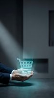 Businessman holding glowing shopping cart hologram in palm, representing digital commerce, online retail, e-commerce technology, and virtual shopping solutions for business applications.