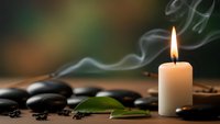Spa candle with smoke and hot stones creating peaceful wellness atmosphere for relaxation and meditation therapy sessions.