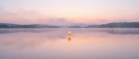 Serene dawn landscape with two hot air balloons floating above calm misty lake waters during sunrise, soft pink and purple sky reflections for travel and nature themes.