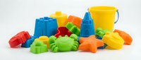 Colorful plastic beach toys and sand molds in bright primary colors including buckets, shovels, and animal-shaped toys for children's outdoor summer play and sandbox activities.