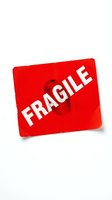 Red fragile shipping label sticker isolated on white background for packaging and delivery warning purposes.
