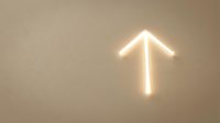 Glowing neon arrow pointing upward on neutral beige wall, symbolizing growth, progress, and direction for business and motivational design projects.