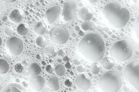 White soap foam bubbles macro photography showing delicate spherical structures and light reflections against bright background, abstract pattern for cleansing concepts.