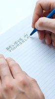 Hand writing believe in yourself motivational message on lined paper with blue pen for personal development and self confidence inspiration.