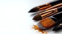 Professional makeup brushes with scattered golden shimmer powder on white background, close-up view with selective focus and copy space for beauty industry.