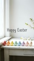 Happy Easter greeting card with pastel colored eggs in a row on a white table near a window with spring blossoms.