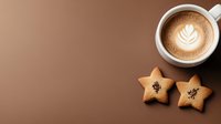 Aromatic cappuccino with latte art rosetta pattern and star-shaped cookies on brown background, copy space for cafe menu or coffee shop promotion.