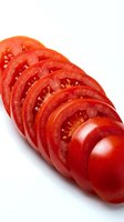 Fresh red tomato slices arranged in row on white background isolated for cooking and food design projects.