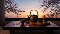 Traditional Japanese tea ceremony setup with cast iron teapot and cups on wooden table during cherry blossom season at sunset for cultural dining experiences.