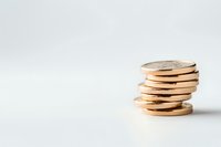 Stack of shiny gold coins on white background with copy space, representing wealth, savings, and financial success in business and investment.