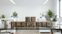 Be prepared for success with wooden letter blocks spelling motivational message on modern office desk surrounded by potted plants.