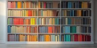 Modern bookshelf with colorful books arranged by spectrum, creating rainbow effect in contemporary interior space. Perfect for library, study, or home office design.