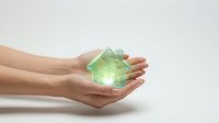 Hands holding glowing green house model symbolizing eco-friendly real estate, sustainable housing, energy efficiency and environmental protection concepts.
