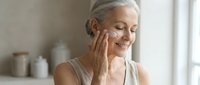 Mature Caucasian woman applying facial cream in bathroom, anti-aging skincare routine, wellness and self-care concept for cosmetic advertising.