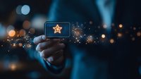 Hand holding glowing card with star icon against blurred bokeh background, magical sparkles and light effects create mystical atmosphere for business excellence.