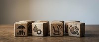 Wooden blocks with insurance icons including family protection, health, disability and time symbols on rustic table for financial planning concepts.