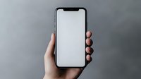 Female hand holding modern smartphone with blank white screen against gray background, mockup for app or responsive web design presentation.