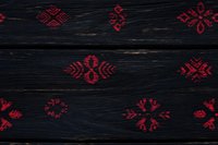 Red folk ornaments on dark wooden background, traditional ethnic pattern design for textiles, wallpaper and seasonal decor. Rustic style surface with cultural motifs.