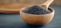 Black poppy seeds in wooden spoon and bowl on dark background, macro food photography with selective focus and natural lighting for culinary design.